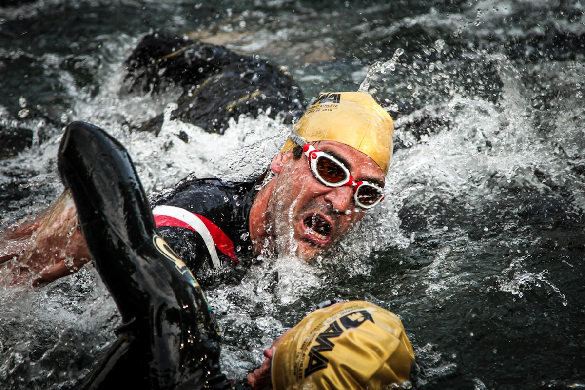 Triathlète qui enfile une combinaison néoprène noire au bord de l'eau