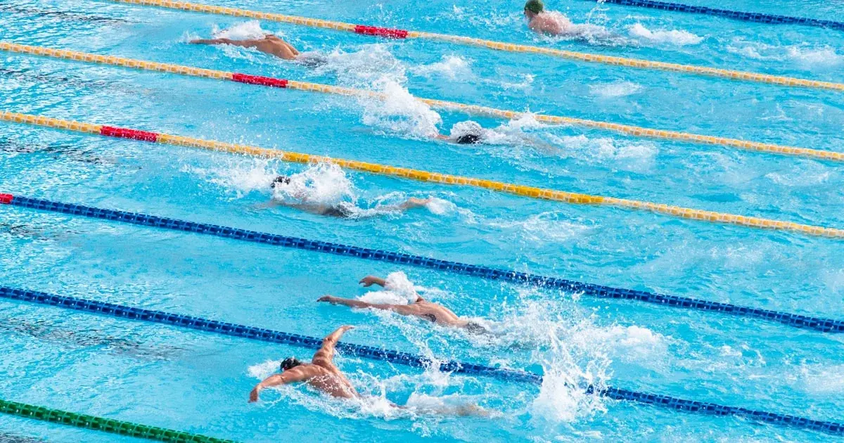 Pull buoy et plaquettes de natation posés au bord d'une piscine avant une séance de triathlon